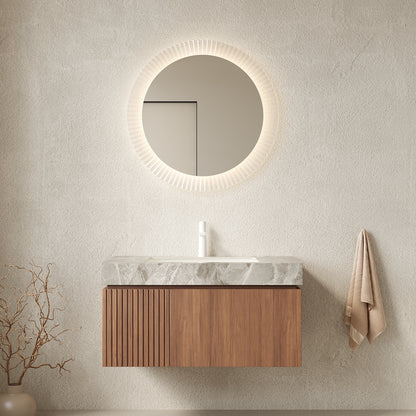 Bathroom vanity with round mirror and wooden cabinet against a beige wall.